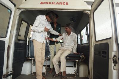A man, right, arrives in an ambulance at the Civil Hospital in Ahmedabad on Tuesday after suffering health problems, allegedly after drinking bootleg liquor.  AFP