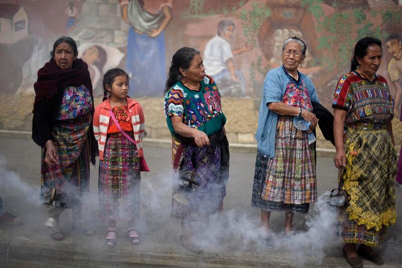 Indigenous women burn incense, as the truck transporting 172 urns containing the remains of victims of the Guatemalan armed conflict (1960-1996), arrives in San Juan Comalapa, about 35 km west of Guatemala City. Johan Ordonez / AFP Photo
