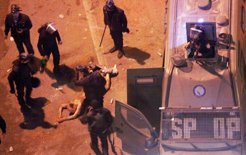 Egyptian riot police beat a man – after stripping him – before dragging him into a police van, during clashes next to the presidential palace in Cairo, Egypt, on February 1, 2013. Khalil Hamra/AP Photo