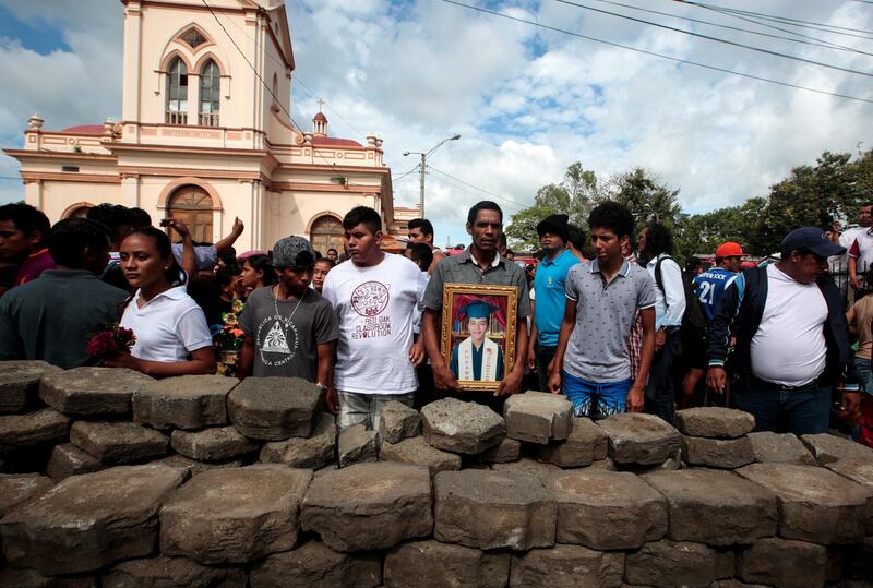 A relative holds a picture of 15-year-old Junior Gaitan, who was shot during recent protests against Nicaraguan President Daniel Ortega's government. Oswaldo Rivas / Reuters