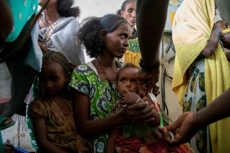 A woman holds a child during a screening for malnutrition by aid groups in the Tigray region of northern Ethiopia. AP
