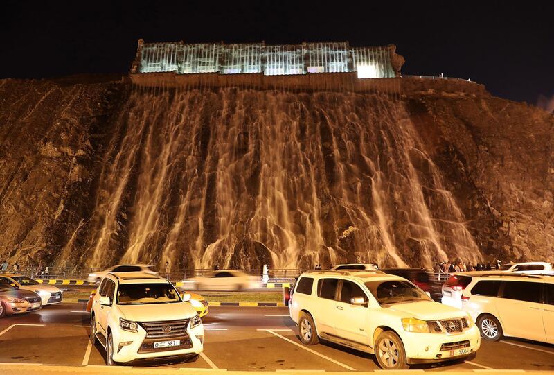 SHARJAH , UNITED ARAB EMIRATES , December 21– 2020 :- People enjoying at the artificial waterfall near the khor Fakkan amphitheatre in Sharjah. ( Pawan Singh / The National ) For News/Standalone/Instagram/Big Picture.