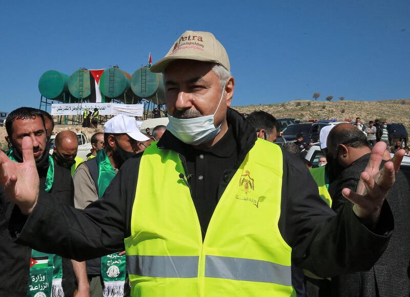 Minister of Agriculture Mohamed Daoudia talks to the media as Jordanians take part in the planting of eucalyptus and carob saplings near the forest of Kufranjah, north of Amman, as part of a reforestation effort that aims to reach 10 million trees in 10 years. AFP