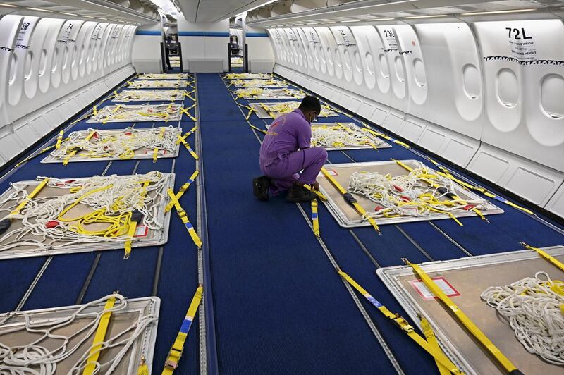 A Sri Lankan Airlines worker gives final touches to an Airbus A330 passenger aircraft, converted as a cargo carrier at Bandaranaike International airport in Katunayaka, near Colombo on June 25, 2020. - The airline said its technical crew carried out the modifications to allow the aircraft  to carry up to 45 tonnes of cargo both in the former passenger deck and the cargo hold at a time when demand for air cargo space has risen while passenger traffic has plummeted due to the coronavirus pandemic. (Photo by ISHARA S. KODIKARA / AFP)