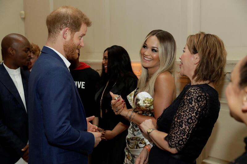Prince Harry speaks with singer Rita Ora and her mum Vera Sahatciu during a reception before the concert. Reuters