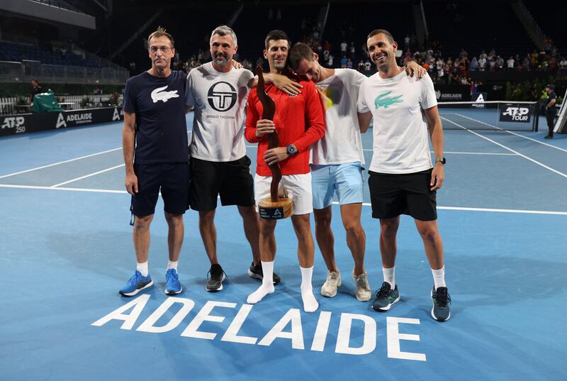 Novak Djokovic celebrates with the trophy and his team after winning the Adelaide International final. Reuters