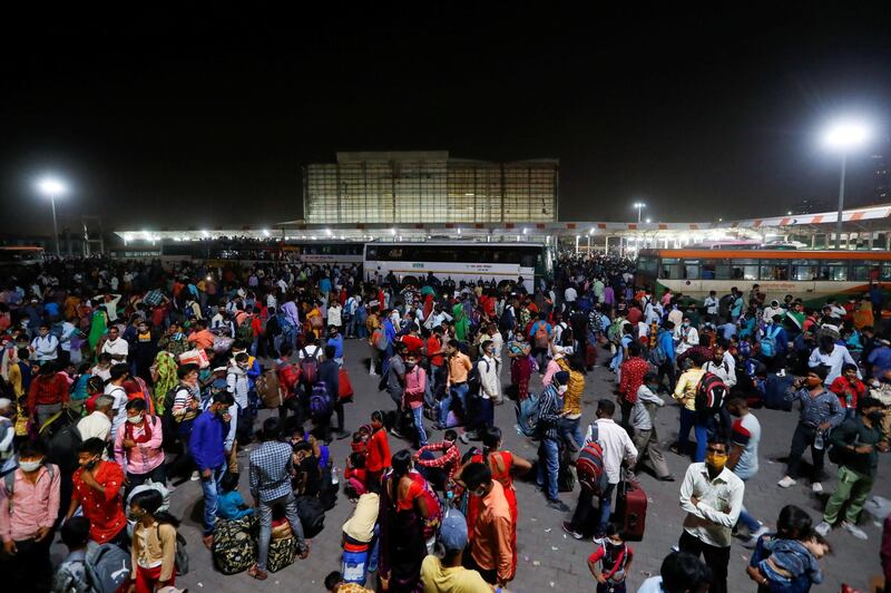 Migrant workers gather at a bus station to board buses to return to their villages after Delhi government ordered a six-day lockdown to limit the spread of the coronavirus disease. Reuters