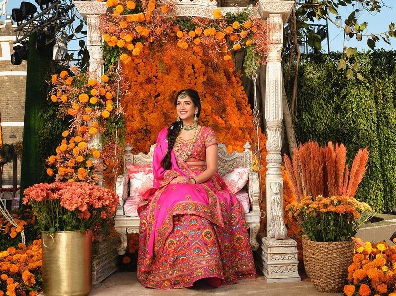 Bride-to-be Radhika Merchant at her mehendi party in a multicolour lehenga embroidered with flowers and mirrors, by designer duo Abu Jani and Sandeep Khosla. Photo: Instagram / abujanisandeepkhosla