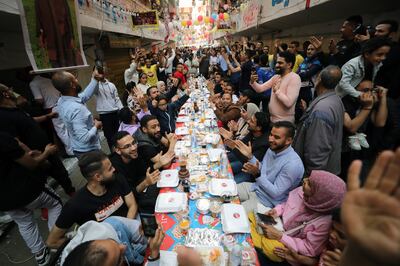 Residents of Ezbet Hamada in the Matareya, Cairo, gather in the streets for Iftar on Thursday. EPA