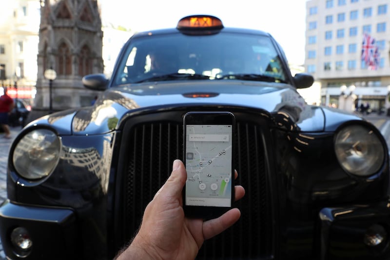 A photo illustration shows the Uber app and a black cab in London, Britain June 26, 2018. REUTERS/Simon Dawson/Illustration
