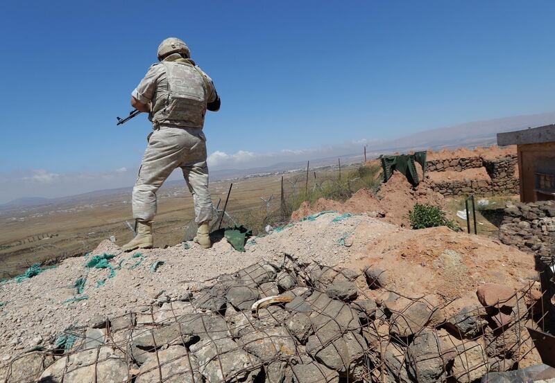 A Russian military police officer stands guard near the village of Tal Kroum, Syria. AP
