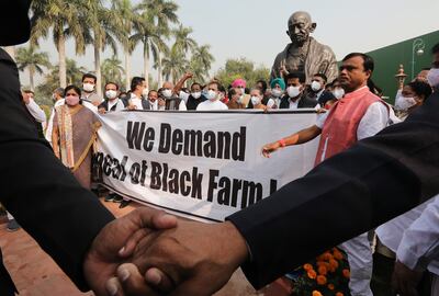 Congress party members and lawmakers gather next to a statue of Mahatma Gandhi to protest against India's farm laws. EPA
