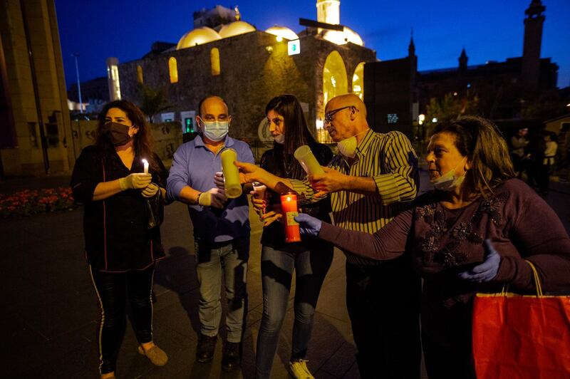 Lebanese Christian Orthodox worshippers light their candles with the 'Holy Fire' which arrived from Jerusalem, at the entrance to Saint George Cathedral in downtown Beirut during the Bright Saturday service held without praying due to the coronavirus pandemic, Beirut, Lebanon.  EPA