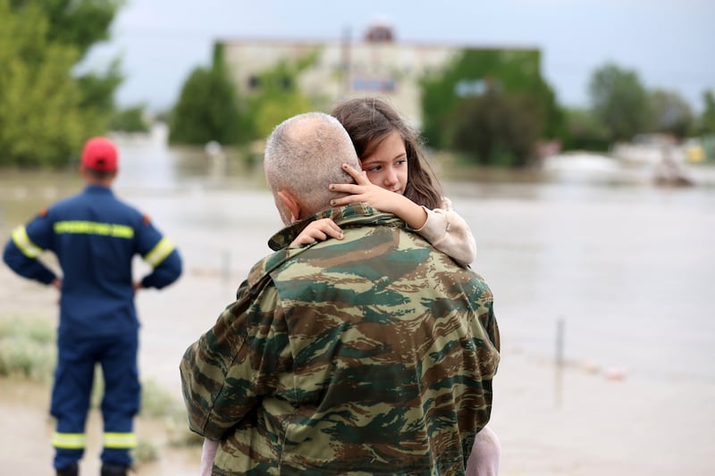 Ilias Chatziliadis holds his daughter Georgia after firefighters helped her evacuate a flooded building in Larissa, central Greece.  AP