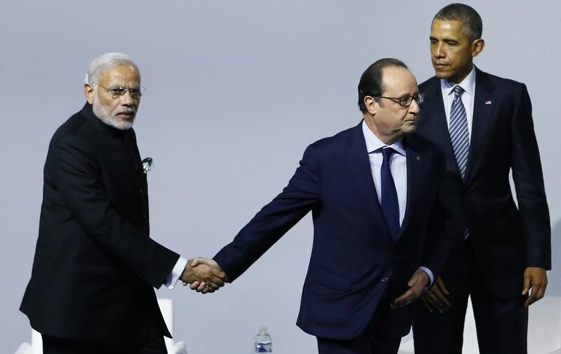 French president Francois Hollande appeared in a hurry as he shook hands with Indian prime minister Narendra Modi at the opening day of the World Climate Change Conference in Paris. Ian Langsdon / AFP