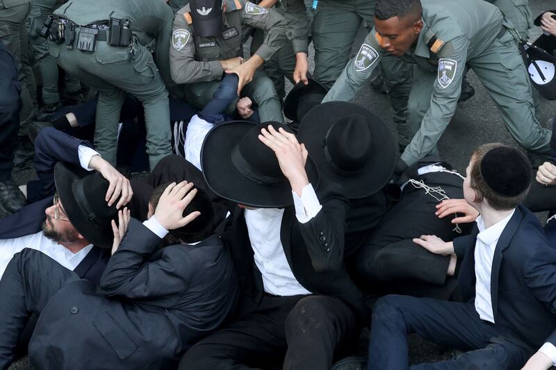 Police remove ultra-Orthodox Jews blocking a road in the central Israeli city of Bnei Brak in protest at plans to end their exemption from military service. AFP