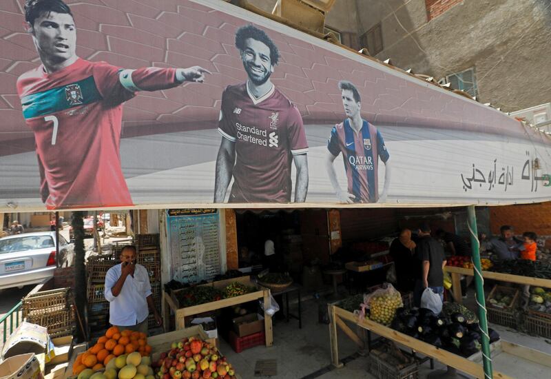 A banner with pictures of the English football club Liverpool player Mohamed Salah, Barcelona's Lionel Messi and Cristiano Ronaldo of the Italian club Juventus, is seen above a cafe that has been transformed into a vegetable shop in Cairo, Egypt. Reuters