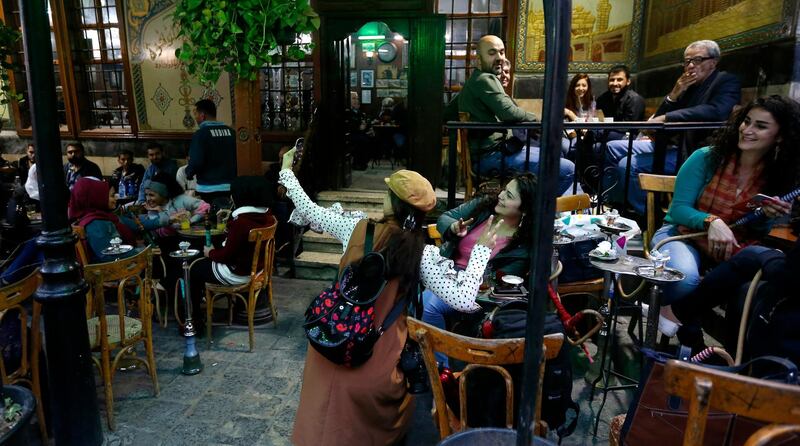 Chinese tourists take pictures with locals at the old city of Damascus, Syria. EPA