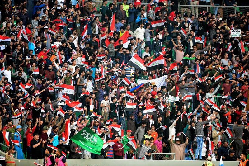 Iraqi and Saudi fans cheer and wave their national flags. Nabil al-Jurani / AP Photo