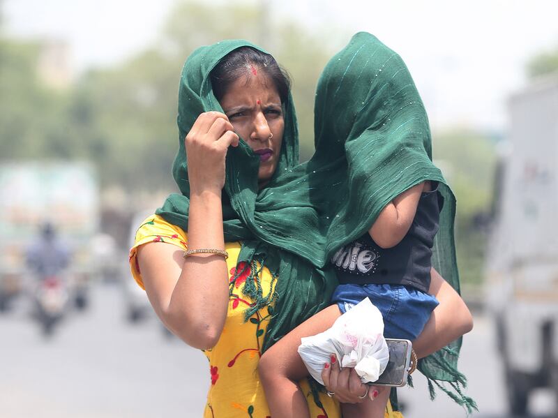 A woman and child in New Delhi try to cover up to avoid the sun during the heatwave last year. EPA