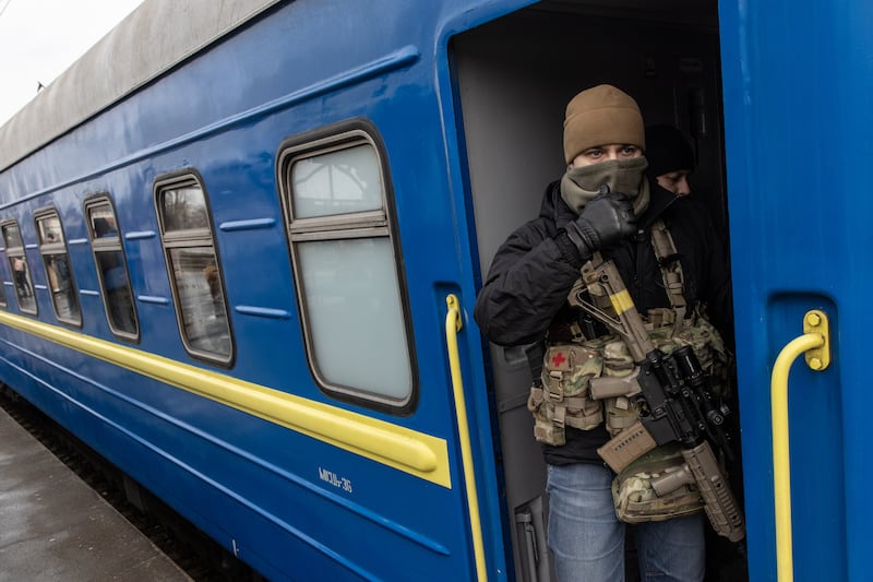 A member of the Ukrainian military guards an evacuation train of women and children who fled fighting in Bucha and Irpin. Getty Images