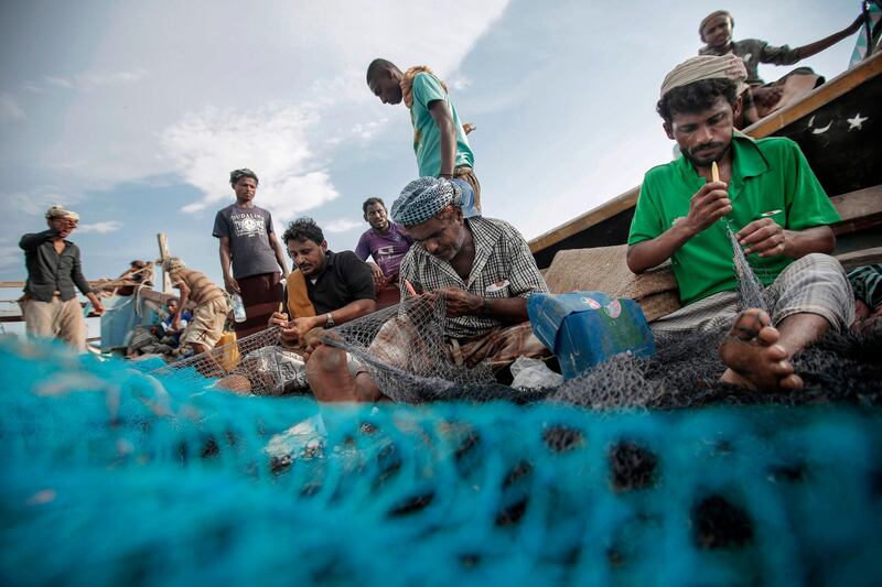 In this Sept. 29, 2018, photo, fishermen work on their nets before a fishing trip at the main fishing port, in Hodeida, Yemen. (AP Photo/Hani Mohammed)