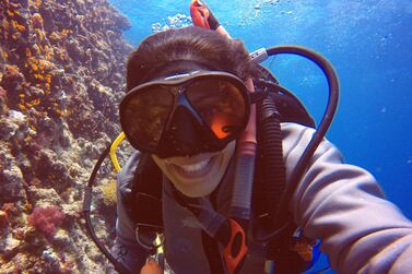 Nouf Alosaimi removes her regulator to smile for a picture under the waves. Courtesy Padi