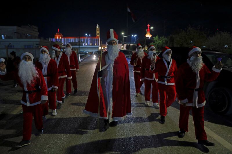 People wearing Santa Claus outfits walk the streets before Christmas in Al Hamdaniya, Iraq. Reuters