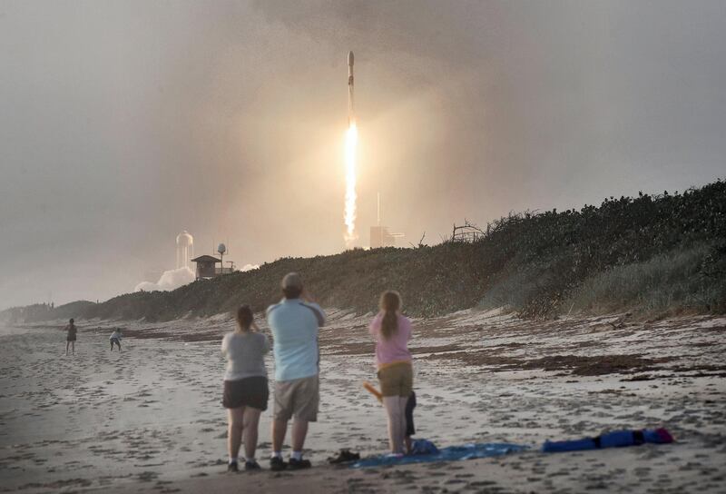 Spectators watch from Canaveral National Seashore as a SpaceX Falcon 9 rocket carrying 60 Starlink satellites launches from pad 39A at the Kennedy Space Center on October 6, 2020 in Cape Canaveral, Florida. This is the 13th batch of satellites placed into orbit by SpaceX as part of a constellation designed to provide broadband internet service around the globe.  (Photo by Paul Hennessy/NurPhoto via Getty Images)