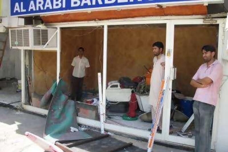 Anwar Hadir, 31, from Pakistan, (in pink shirt), owner of Al Arabi Barber Shop. He bought the shop a year ago for Dh90,000. It was completely destroyed. He is scrambling to get the Dh40,000 he needs to repair it in order to open up for Eid. For him it has been a double tragedy as his family's home in Pakistan was destroyed in the floods there. His parents were counting on him to help them through the money he made from his barber shop. Now he can't help them or himself.

Essam Al Ghalib / The National
