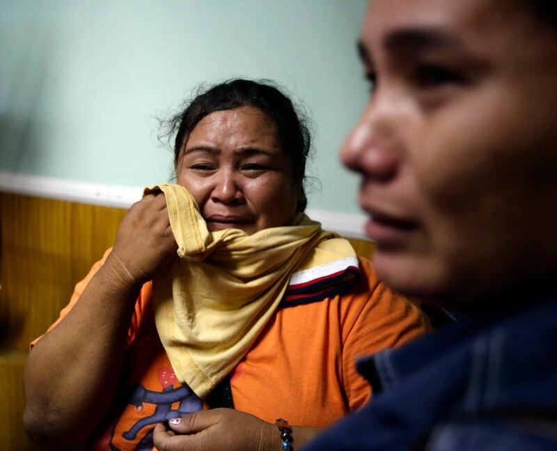 A survivor, left, of the ill-fated passenger ferry MV Thomas Aquinas, cries as she is reunited with her relatives at the ticketing office of a shipping company, Saturday Aug. 17, 2013, a day after the ferry collided with a cargo ship, the MV Sulpicio Express Siete, off the waters of Talisay city, Cebu province in central Philippines. Divers combed through the sunken ferry Saturday in search of dozens of people missing after the collision that sent passengers jumping into the ocean and leaving many others trapped. At least 31 were confirmed dead and hundreds rescued. (AP Photo/Bullit Marquez) *** Local Caption ***  Philippines Ferry Collision.JPEG-0a815.jpg