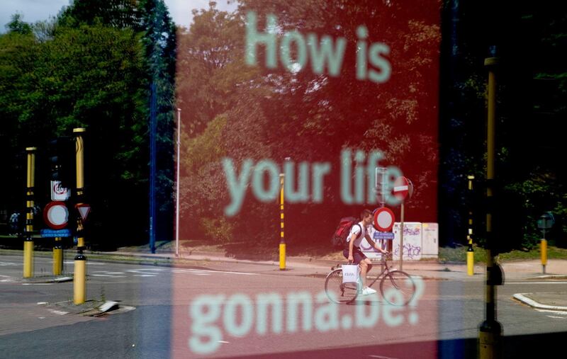 A man on a bike is reflected in a shop window in Ghent, Belgium. AP