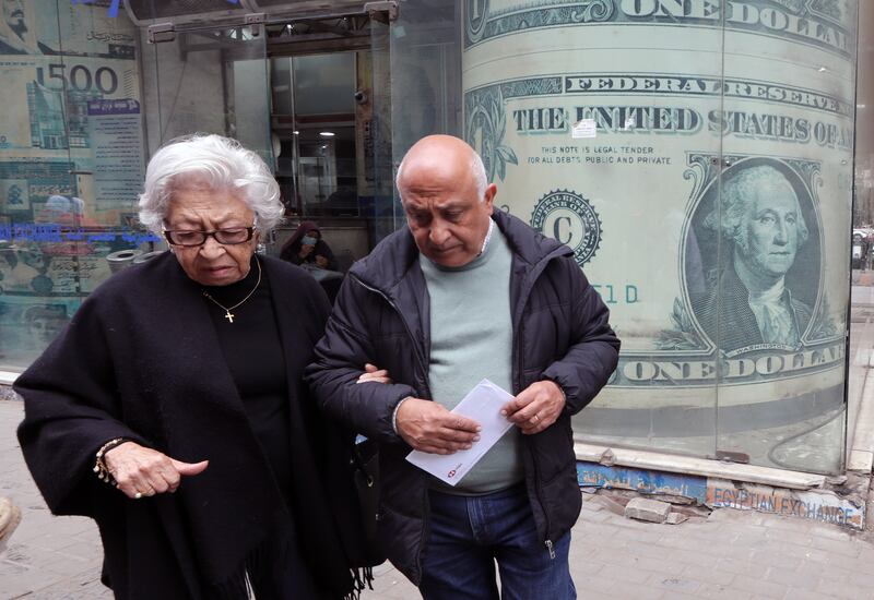 People walk outside a currency exchange office in Cairo. The Egyptian pound dropped to a record low against the US dollar earlier this year. EPA