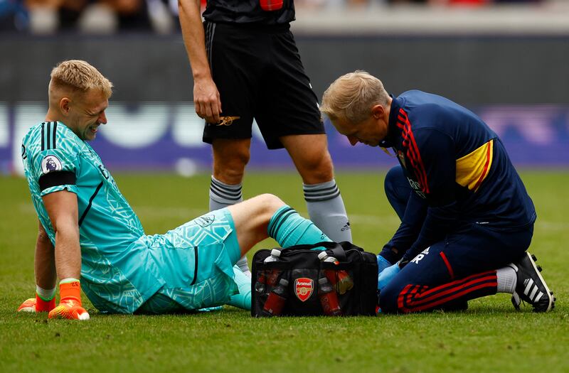 Arsenal's Aaron Ramsdale receives medical attention after sustaining an injury. Reuters