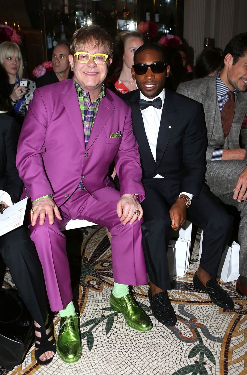 Elton John, in a purple suit, green checked shirt and metallic green shoes, and Tinie Tempah on the front row for the Richard James spring/summer 2013 show in London on June 17, 2012. Getty Images