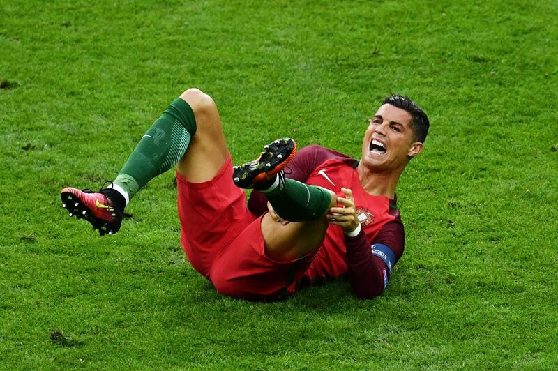 PARIS, FRANCE - JULY 10: Cristiano Ronaldo of Portugal holds his knee during the UEFA EURO 2016 Final match between Portugal and France at Stade de France on July 10, 2016 in Paris, France.  (Photo by Dan Mullan/Getty Images)