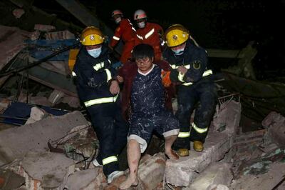 A man is helped out of the rubble of a collapsed hotel by rescuers in Quanzhou, in China's eastern Fujian province on March 7, 2020. Around 70 people were trapped after the Xinjia Hotel collapsed on March 7 evening, officials said. - China OUT
 / AFP / STR
