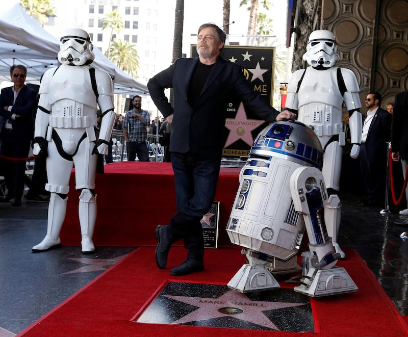 Actor Mark Hamill poses with 'Star Wars' characters R2-D2 and Stormtroopers after unveiling his star on the Hollywood Walk of Fame. Reuters