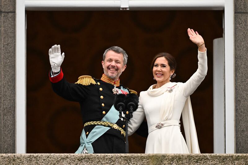King Frederik X and Queen Mary of Denmark wave from the balcony of Christiansborg Palace in Copenhagen on Sunday. AFP