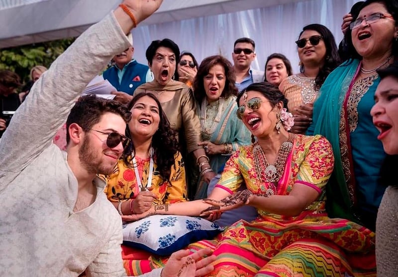 In this Friday, Nov. 30, 2018 handout photo released by Raindrop Media, Bollywood actress Priyanka Chopra and Nick Jonas celebrate during a mehendi ceremony, a day before their wedding, at Umaid Bhawan in Jodhpur, India. (Raindrop Media via AP)