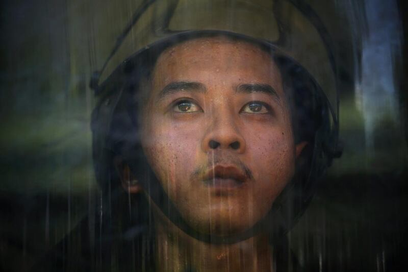 A member of an Air Force military force perspires behind his shield after anti-government protesters broke into an air force base in Bangkok. Protesters seeking to oust Thailand's government broke into the grounds of an air force compound on Thursday where the acting prime minister was meeting the Election Commission to fix a date for new polls, forcing him to flee. Damir Sagolj / Reuters