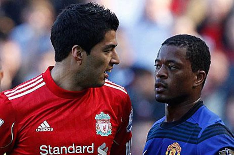 Luis Suarez, the Liverpool striker, left, stares at Patrice Evra, the Manchester United left-back, during their 1-1 draw at Anfield yesterday.