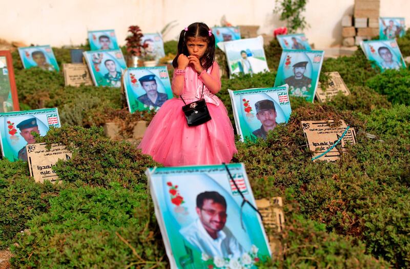 EDITORS NOTE: Graphic content / TOPSHOT - A Yemeni girl stands near the grave of a relative in a cemetery in the capital Sana'a on June 15, 2018. Muslims worldwide celebrate Eid al-Fitr marking the end of the fasting month of Ramadan. / AFP / Mohammed HUWAIS
