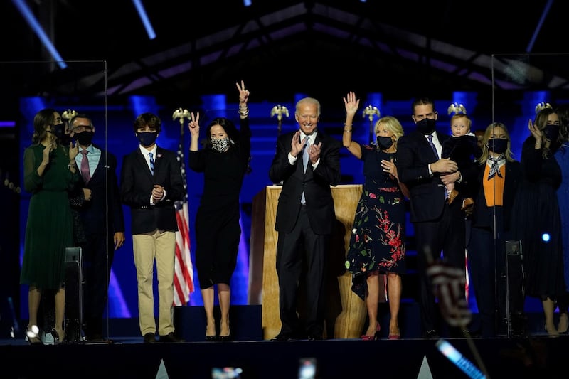 TOPSHOT - US President-elect Joe Biden, cente, with his wife Jill Biden and members of this family  salute the crowd on stage after delivering remarks in Wilmington, Delaware, on November 7, 2020. / AFP / POOL / Andrew Harnik
