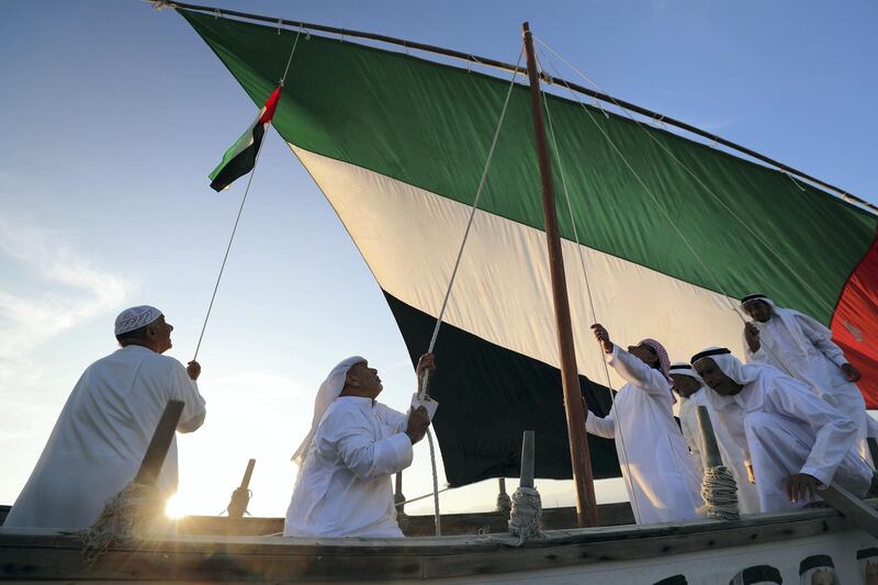 Fujairah, United Arab Emirates - November 04, 2019: Emirati fisherman hoist the UAE flag on their boat in Dibba. Monday the 4th of November 2019. Fujairah. Chris Whiteoak / The National