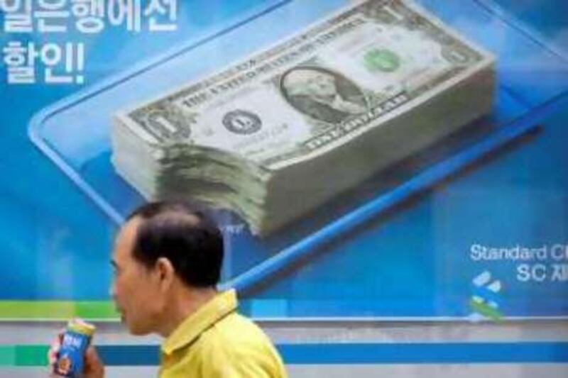 A South Korean man walks past a bank's foreign currency exchange advertisement board in Seoul, South Korea, Sunday, Oct. 19, 2008. South Korea announced measures Sunday to shore up its banks by guaranteeing their external debt and pumping more money into the banking sector amid the global financial crisis. (AP Photo/ Lee Jin-man) *** Local Caption ***  LJM104_South_Korea_Credit_Crisis.jpg
