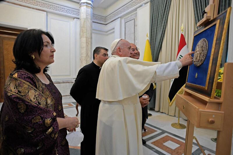 Iraqi President Barham Salih and his wife Sarbagh show Pope Francis one of the presidential gifts. AFP