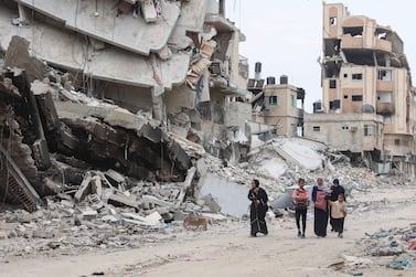 Palestinian women and children walk past the ruins of buildings destroyed by earlier Israeli bombardment in Gaza City on April 8, 2024, amid the ongoing conflict between Israel and the Palestinian Hamas militant group.  (Photo by AFP)