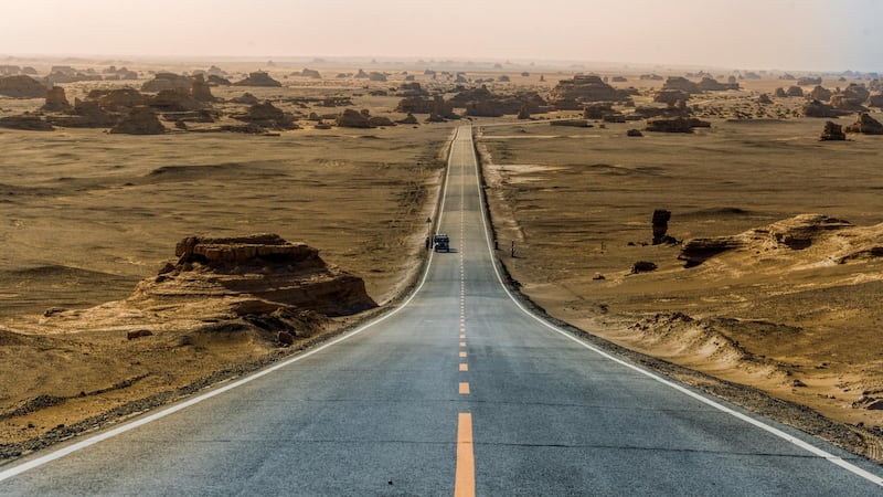 A road cuts through the desert.