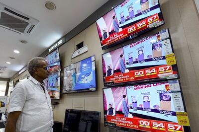 A man watching television waits for the release of exit polls published after voting concludes in India's general election. AFP